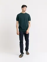 Remera de punto color beige, de manga corta y cuello redondo.