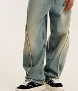 Pantalón de jean negro estilo super baggy, con diseño holgado, tiro alto y detalles de costuras deshilachadas a lo largo de las piernas.
