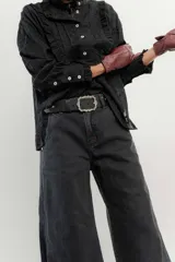 Pantalón de jean de tiro medio y pierna ancha, confeccionado en denim 100% algodón. Diseño con 5 bolsillos y pespuntes a contratono.