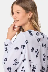 Blusa blanca estampada con flores azul marino y rosa, de manga larga y cuello redondo con abertura en la espalda.