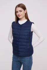 Chaleco acolchado color verde militar con cierre de botones a presión.