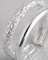 Anillo doble de plata 925, compuesto por una banda superior lisa y pulida, y una banda inferior con textura martillada.