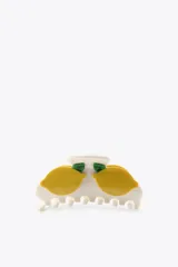 Pinza de pelo grande, tipo garra, de color blanco con dos aplicaciones de limones amarillos y hojas verdes.