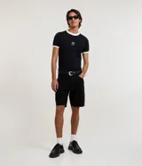 Bermuda slim de sarga color negro para hombre, de corte ajustado, con cierre de botón y cremallera, y bolsillos funcionales.