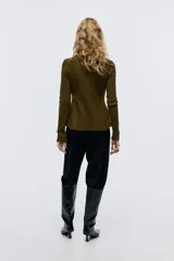 Saco de punto acanalado con cuello redondo, cierre frontal con botones metálicos y diseño entallado con peplum en la cintura.