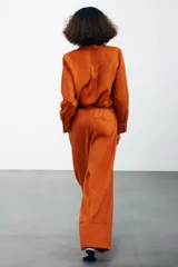 Camisa color coral confeccionada en lino 100%, de corte recto, con cuello solapa, manga larga con puños abotonados y cierre frontal con botones.