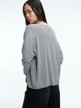 Sweater de tejido de punto en color gris, con cuello redondo y mangas tres cuartos de corte holgado.