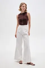 Pantalón de jean blanco de tiro alto, corte ancho y recto, con bolsillos laterales.
