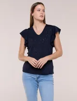 Blusa blanca de tejido calado estilo broderie con escote en V y mangas cortas tipo mariposa.