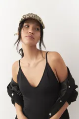 Malla entera de traje de baño color negro, con escote redondo al frente y espalda descubierta con tiras regulables que se atan.