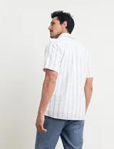 Camisa de manga corta a rayas verticales color natural y celeste, con cuello clásico, cierre frontal con botones de madera y bolsillo de parche en el pecho.