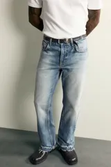 Jeans flare fit de denim de algodón en color celeste con lavado efecto desgastado. Presentan diseño de cinco bolsillos, tiro medio, cierre frontal con cremallera y botón, y bajo con acabado irregular.