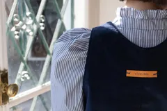 Chaleco de pana azul marino con cuello a la base, espalda irregular y terminación desflecada.