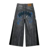 Jean de corte amplio en color negro con efecto acid wash. Presenta cierres laterales metálicos que permiten ajustar la silueta entre corte recto, oxford o baggy. Incluye una estampa gráfica de gran tamaño en la parte trasera con detalles bordados, bolsillos amplios y una etiqueta de cuero legítimo en la cintura.