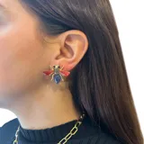 Aros pequeños con forma de mosca, hechos en base metálica dorada y resinas de colores.