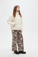 Campera puffer negra con cuello alto, cierre frontal oculto y puños tejidos acanalados. Diseño acolchado con bolsillos laterales.