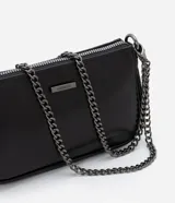 Bolso pequeño transversal negro, confeccionado en PU, con correa larga de cadena. Cierre por cremallera y placa metalizada con el logo de la marca.