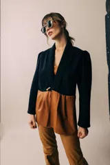 Blazer sastrero bicolor que combina parte superior de lana negra con solapa chal y parte inferior de cuero tostado con diseño fruncido, de mangas largas.