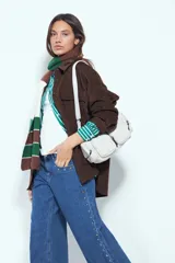 Jean de corte recto y silueta relajada, confeccionado en denim azul. Presenta una hilera de tachas metálicas decorativas a lo largo de los laterales de ambas piernas.