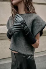 Guantes largos combinados con efecto piel y tejido de punto acanalado de lana. Presentan un diseño con abertura en el dorso y detalle de botón a presión.