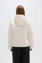 Campera acolchada de color blanco con diseño capitoneado en forma de rombos, manga larga, capucha y cierre frontal con botones a presión dorados.