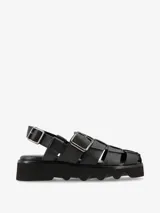 Sandalias negras de cuero con plataforma y tiras de cuero entrelazadas con hebillas metálicas.