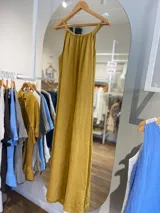 Vestido largo de lino color negro oscuro, con escote fruncido y tirantes finos ajustables. Presenta aberturas laterales en el ruedo.