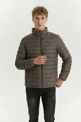 Campera puffer de diseño acolchado, color gris oscuro, con cuello alto, cierre frontal completo y bolsillos laterales con cierre.