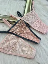 Pack de tres microtangas de encaje con diseño floral, cuentan con tiras laterales regulables y bordes con terminación en cinta elástica. El set incluye una prenda negra, una blanca con estampado floral negro y una beige con estampado floral negro.