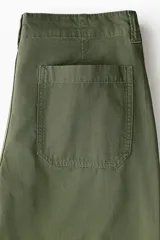 Pantalón de corte relajado confeccionado en tejido ripstop, con cierre de botón a presión, bolsillos al bies y bolsillos traseros de parche. Presenta costuras horizontales en las piernas y cordón ajustable en los bajos.