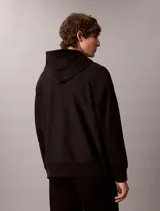 Buzo con capucha negro Calvin Klein, de felpa suave, con cordones ajustables, bolsillo tipo canguro y pequeño monograma bordado en el pecho.