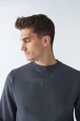 Buzo de felpa color rosa con logo estampado, cuello redondo, mangas largas y puños.