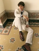 Pantalon de lino color beige, de corte recto con bolsillos delanteros y traseros con cierre de botón.
