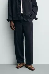 Pantalón straight fit color negro, confeccionado en popelín de algodón, con cintura elástica y bolsillos frontales.