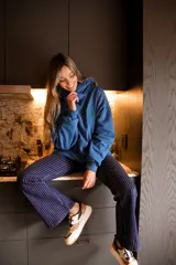 Canguro azul con capucha y logo de flor bordado en verde.