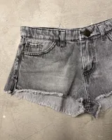 Short de jean gris con efecto lavado, tiro alto y ruedo desflecado.
