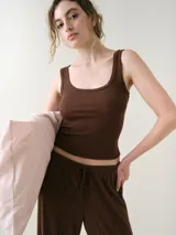 Musculosa básica entallada de tela pointelle color blanco, con escote redondo y detalle de ondas en los bordes.