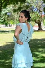 Vestido largo color beige con volados en el escote y falda escalonada.