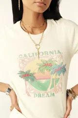 Remera crop de manga corta color crema, con cuello redondo y estampado de inspiración californiana.