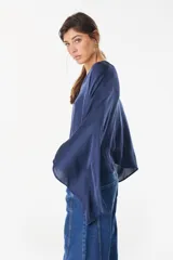 Blusa de algodón azul marino con escote en V, mangas murciélago amplias y diseño corto de corte asimétrico.