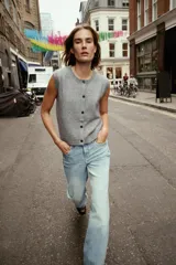 Chaleco de punto suave con cuello redondo, diseño sin mangas y cierre frontal con botones. Presenta terminaciones en rib en el cuello, sisas y ruedo.