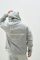 Buzo canguro gris melange con capucha, cordones ajustables y bolsillo tipo canguro. Estampado frontal con el logo "brokers" y la frase "Good Time Makers".