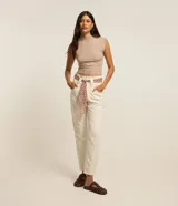 Pantalón mom de jean color beige, de tiro alto y corte holgado con piernas ligeramente cónicas. Cuenta con bolsillos laterales y trabillas en la cintura. Incluye un pañuelo estampado con diseño de animal print.