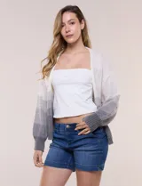 Cárdigan de punto abierto y calado con silueta holgada y hombros caídos, diseño degradado en tonos blanco, rosado y rojo. Presenta frente abierto sin botones y mangas largas abullonadas con terminación en puño acanalado.