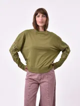 Buzo color verde oliva de corte holgado con cuello redondo y mangas largas con calados.