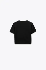 Camiseta cropped color amarillo, de corte slim fit, cuello redondo y manga corta.