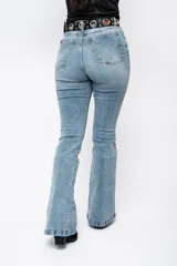 Pantalón de jean estilo campana con tiro alto, confeccionado en denim con elastano. Presenta un lavado claro y corte ajustado en la parte superior que se ensancha desde la rodilla hacia el ruedo.