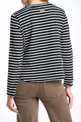 Remera de manga larga con diseño de rayas horizontales en blanco y negro, cuello redondo y corte ajustado al cuerpo.