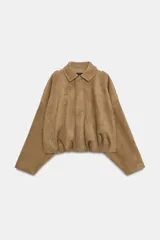 Chaqueta de efecto ante color marrón claro, con cuello solapa, manga larga con trabillas en los hombros y bajo abullonado. Cierre frontal con cremallera y botones ocultos por solapa.