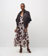 Vestido largo de corte evasé confeccionado en chiffon con estampado animal print. Presenta escote en V, breteles finos ajustables y diseño sin mangas. Incorpora una capa adicional en el ruedo que aporta movimiento y fluidez a la prenda.